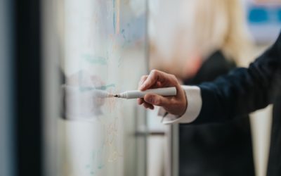 A,Business,Professional,Writes,On,A,Glass,Whiteboard,With,A